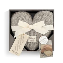 Heart-shaped gray knitted gift in a box with a cream ribbon
