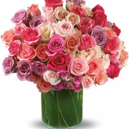 Mixed pink and lavender roses in a glass vase