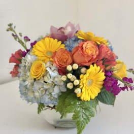 Colorful bouquet with roses, hydrangea, and yellow daisies in a vase