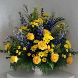 Yellow roses and purple flowers in a white vase