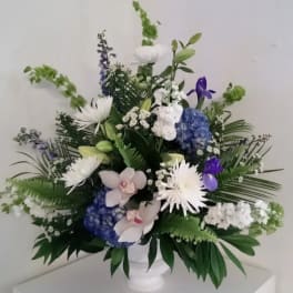 White and blue floral arrangement in a white vase