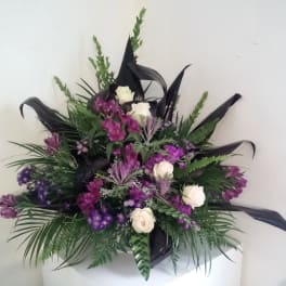 Purple and white floral arrangement with black ribbon accents