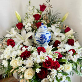 Red and white floral arrangement with a blue-and-white urn