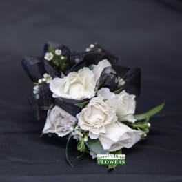 White rose bouquet with black ribbon on dark fabric