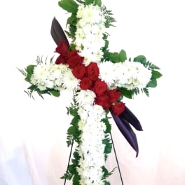 Cross-shaped floral tribute with red roses and white chrysanthemums