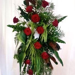 Tall standing arrangement of red roses and mixed greenery