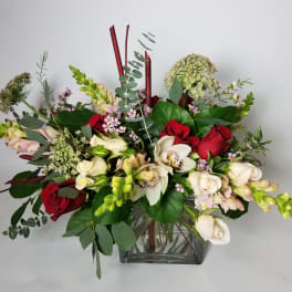 Mixed bouquet of red and white flowers in a clear glass vase