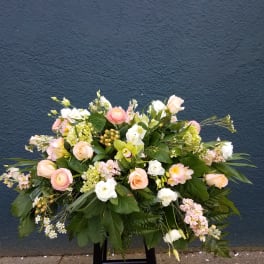 Large pastel floral arrangement with roses and white blooms