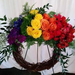 Rainbow rose wreath on a grapevine frame with mixed greenery