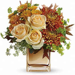 Cream roses and autumn chrysanthemums in a clear glass vase