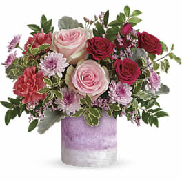 Pink and red rose bouquet in a lavender vase