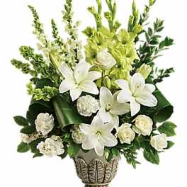 White lilies and roses in a decorative vase with green flowers