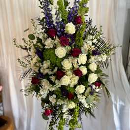 Tall floral spray with red and white roses, purple blooms, and green accents