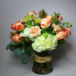 Bouquet of red-edged roses and pale hydrangeas in a glass vase