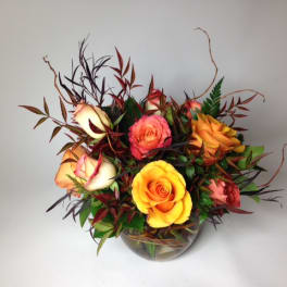 Arrangement of multicolored roses in a clear glass bowl