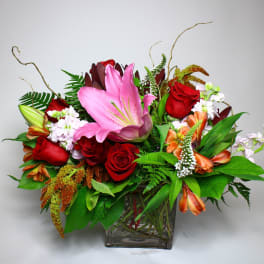Mixed bouquet with pink lilies and red roses in a glass vase