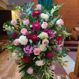 Large pink and white floral arrangement on a stand