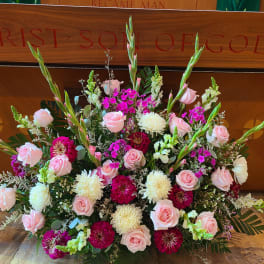 Large floral arrangement with pink roses, white mums, and magenta blooms