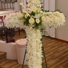 White floral cross on a stand with calla lilies and chrysanthemums