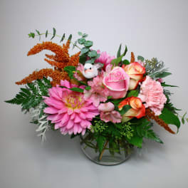 Pink and peach flower arrangement in a clear glass vase