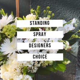White floral standing spray with mixed blooms and greenery
