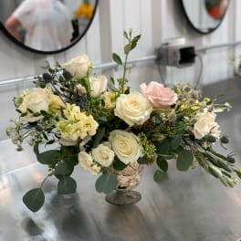 Cream and blush rose arrangement in a pedestal vase