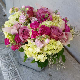 Pink and yellow mixed bouquet in a square glass vase