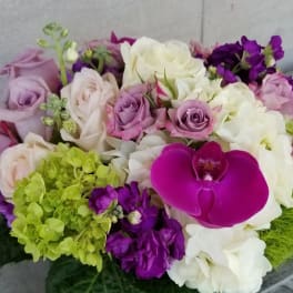 Bouquet of pink, white, and purple flowers with a bright magenta orchid