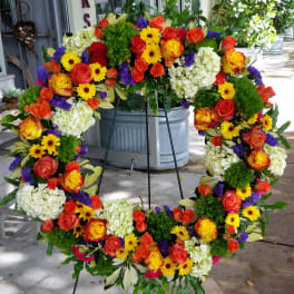 Large circular floral wreath on a stand with multicolored blooms
