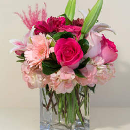 Pink mixed bouquet in a clear square glass vase