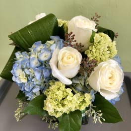 Bouquet of white roses and blue hydrangeas with green accents