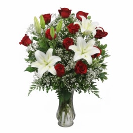Red roses and white lilies in a clear glass vase