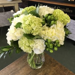 White and pale green bouquet in a clear glass vase
