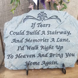 A memorial stone plaque with a sympathy quote on a stand.