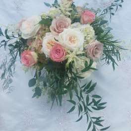 Pastel rose bouquet with white and pink blooms on embroidered fabric