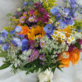 Colorful mixed bouquet with sunflowers, roses, and blue flowers