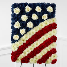 Floral standing spray arranged as an American flag with red, white, and blue flowers