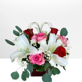 Bouquet of red and pink roses with white lilies in a vase