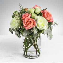 Pink and pale green roses with carnations in a clear glass vase
