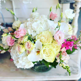Pastel bouquet of roses, hydrangeas, and white orchids in a glass vase