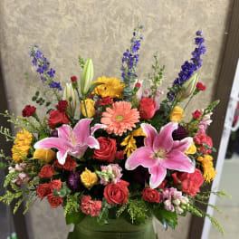 Colorful mixed bouquet with pink lilies, roses, and gerbera daisies in a vase
