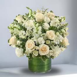 White rose and alstroemeria arrangement in a green glass vase