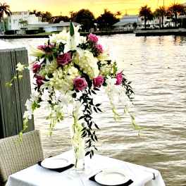 Tall floral centerpiece with pink roses and white lilies in a clear vase