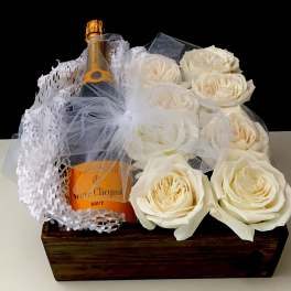 Champagne bottle in a wooden box with white roses and tulle