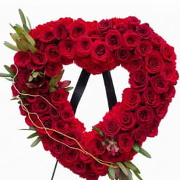 Heart-shaped red rose wreath on a stand