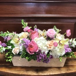 Low floral centerpiece with pink and white blooms in a rectangular basket