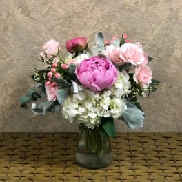 Pink and white flower arrangement in a glass vase