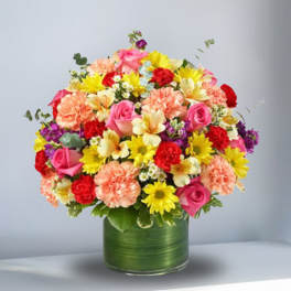 Mixed bouquet of pink, yellow, red, and peach flowers in a green vase
