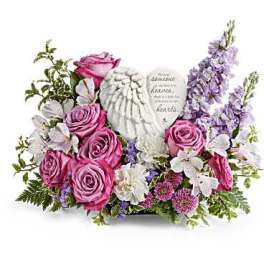 Pink roses and white flowers arranged around a memorial heart plaque