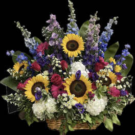 Large basket arrangement with sunflowers, roses, and mixed blooms